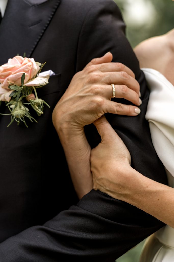 Nært bilde av hender med giftering og blomsterdetaljer